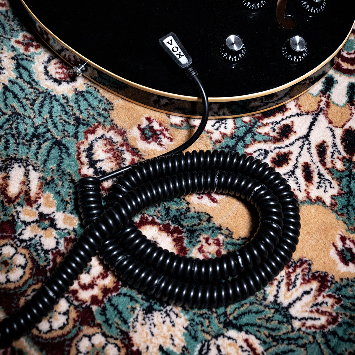 Vintage Coil Cable plugged into a black electric guitar